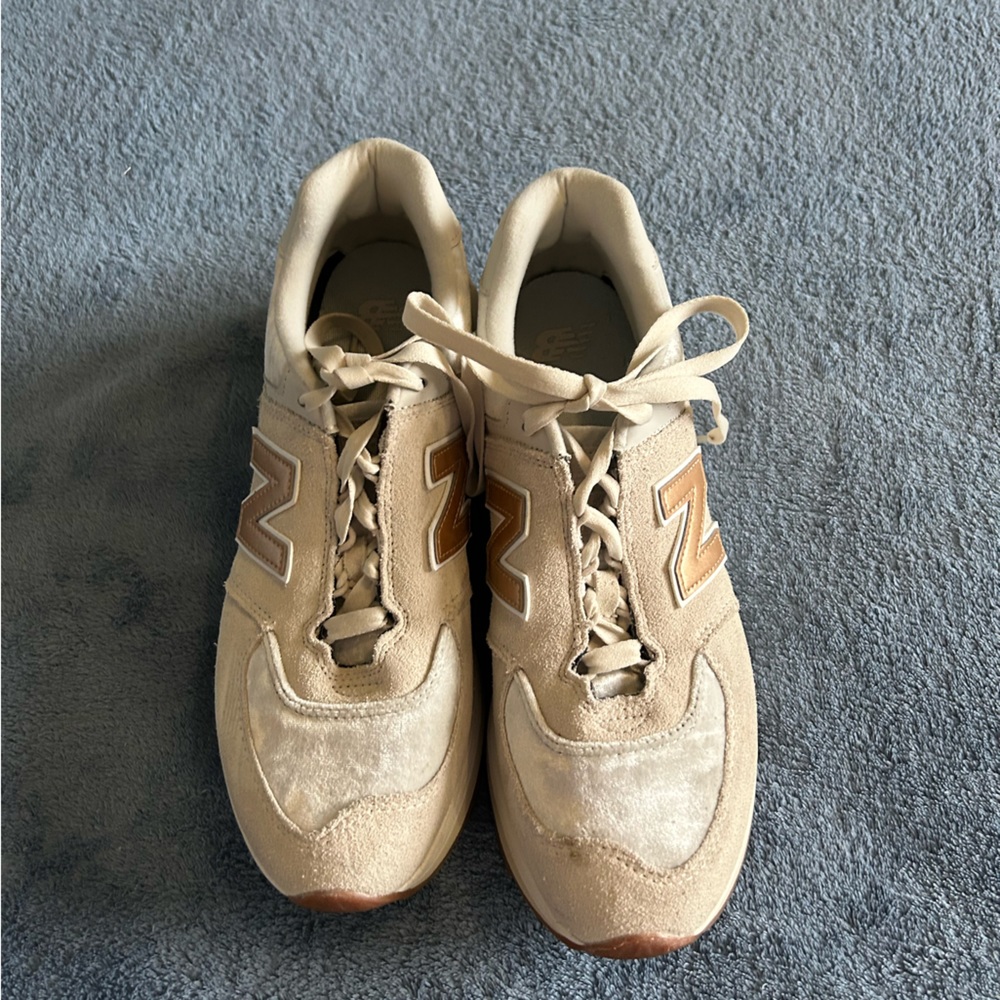 Gently worn Ladies gold tone New Balance athletic shoes.